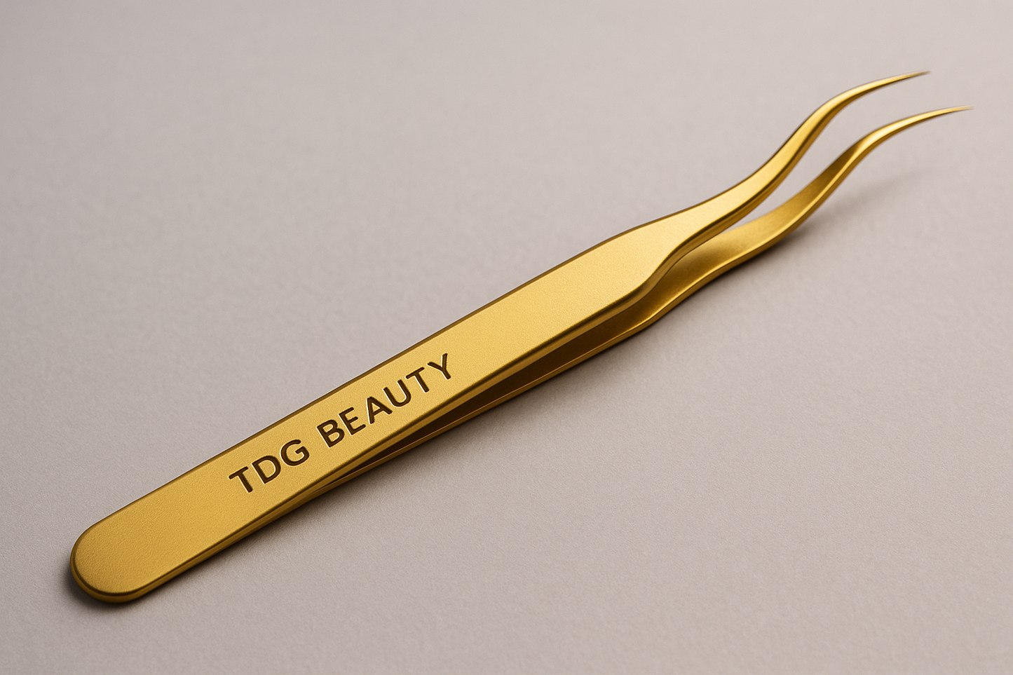 une pince de couleur or qe les techniciennes utilise pour manipulez les cils de leurs clientes avec ecrit tdg beauty dessus