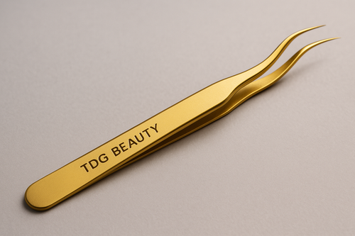 une pince de couleur or qe les techniciennes utilise pour manipulez les cils de leurs clientes avec ecrit tdg beauty dessus